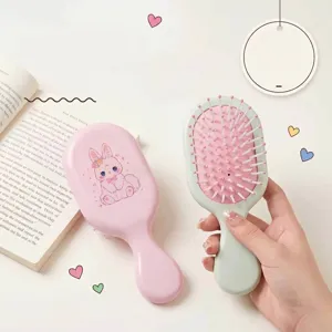 Close-up of a cute pink rabbit cartoon air cushion massage hairbrush held in hand