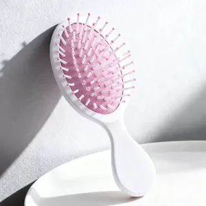 Detailed view of the mini pink and white air cushion hairbrush for children's detangling