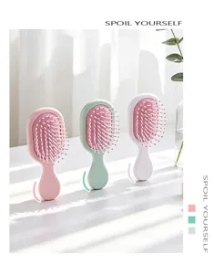 Three mini portable air cushion hairbrushes in pastel pink, green, and white colors