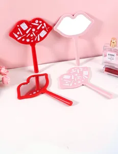 Detail shot of lip-shaped portable hand mirrors in red and pink for makeup