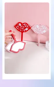 Detailed view of red and pink lip-shaped handheld makeup mirrors for cosmetic use