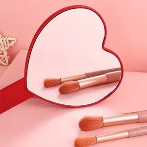 Red heart-shaped handheld makeup mirror for portable daily beauty and grooming use