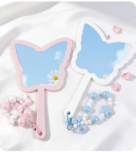 Detail view of butterfly handheld mirrors with cute pastel beaded decorative charms.