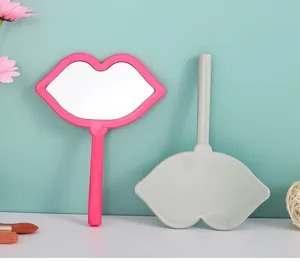 Lip-shaped hand-held makeup mirrors in pink and grey showing front and back details