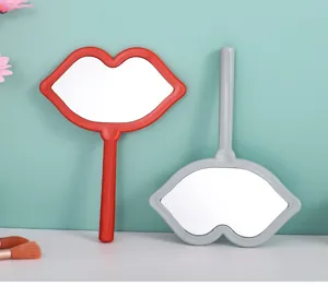 Creative lip-shaped handheld makeup mirrors in red and grey colors for daily touch-ups.