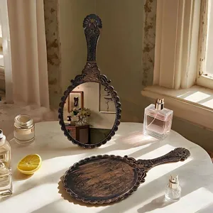 Vintage bronze handheld makeup mirror with ornate floral patterns for dressing table vanity