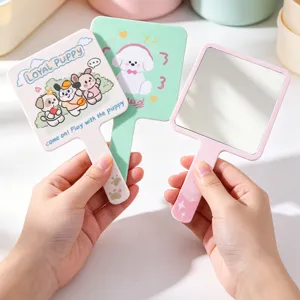 Miroir de maquillage carré avec des illustrations mignonnes de chiots et manche pastel.