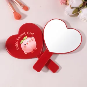 Dettaglio di specchi a mano a forma di cuore con design pesca e cornice rossa