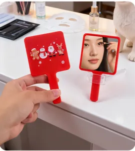 Detail of red square hand-held makeup mirror with Christmas themed characters design.