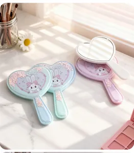 Detailansicht herzförmiger Handspiegel mit niedlichem Hasenprint und Glitzerelementen