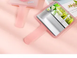 Pink handheld makeup mirror detail showing square design and cute text