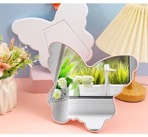 Detail view of a butterfly-shaped pink desk mirror placed in a cozy and elegant vanity setting