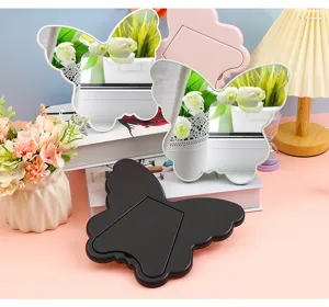 Detailed view of butterfly shaped desktop makeup mirrors in white, pink and black colors