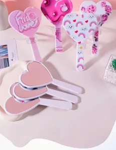 Detailed view of various cute heart-shaped hand mirrors with colorful and artistic prints