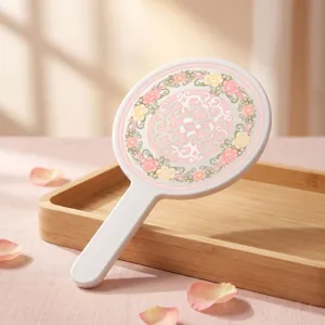 Close-up of elegant pink floral pattern on a white hand-held round vanity mirror detail