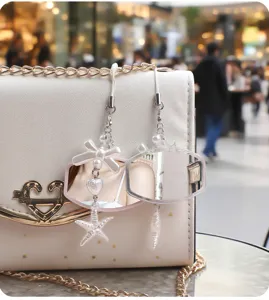 Detailopname van draagbare make-upspiegelhangers met strik en zeester op een witte tas