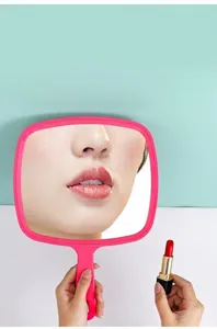 Detailed macro view of a high-definition pink handheld cosmetic mirror with ergonomic handle