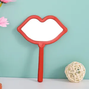 Portable red lip-shaped hand mirror for makeup application and daily beauty grooming