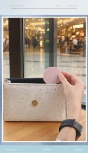 Close-up of a pink portable round makeup mirror being placed into a glittery bag