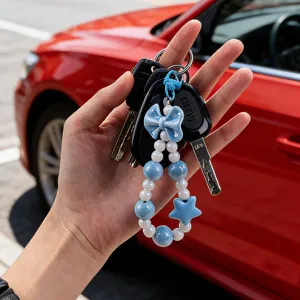 Close-up of blue beaded keychain charm with bow and star details on car keys