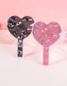 Vista detallada del espejo de maquillaje en forma de corazón con textura de onda de agua