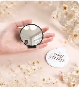 Detail view of a portable folding mirror featuring a Vintage Times floral cover design.