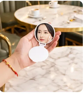 Portable white folding makeup mirror shown in a cozy cafe lifestyle setting