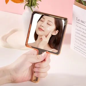 Elegant handheld makeup mirror with electroplated rose gold frame for portable beauty.