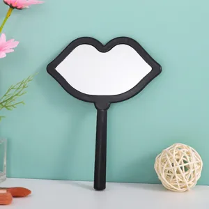 Lip-shaped handheld makeup mirror in black frame for portable beauty touch-ups