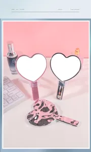 Detalle de un espejo de maquillaje en forma de corazón con textura metálica ondulada