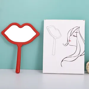 Close-up detail of a red lip-shaped handheld makeup mirror and its white retail packaging box.
