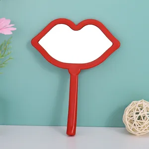 Close-up of a creative red lip-shaped hand mirror for portable makeup application