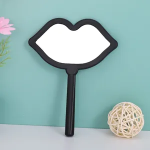 Detailed view of the cute lip-shaped hand mirror with a sleek black frame design.
