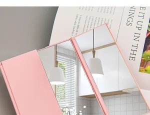 Close-up detail of a pink tri-fold portable makeup mirror with clear mirror reflection