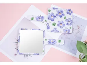 Detail view of floral square handheld mirror with elegant purple embossed flower pattern