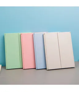 Compact tri-fold portable makeup mirrors in multiple pastel colors shown closed on desk