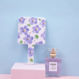 Elegant handheld square makeup mirror with purple 3D floral relief pattern for portable use
