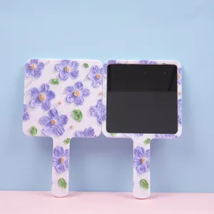 Elegant square handheld makeup mirror featuring a purple floral relief pattern design