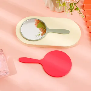 Professional round handheld makeup mirrors with plastic handles on a pink background