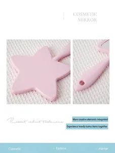 Detailed macro view of star shaped pink handheld cosmetic mirror with hanging hole handle