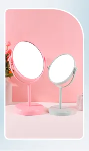 Close-up of two rotating desktop makeup mirrors in pink and blue pastel colors