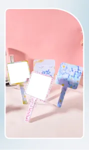 Variété de miroirs de maquillage floraux à main sur fond rose élégant.
