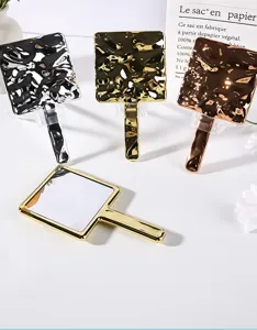 Close-up detail of square handheld mirrors featuring unique hammered metallic ripple texture