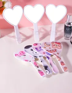 Detailed view of cute heart-shaped handheld mirrors with various cartoon patterns.