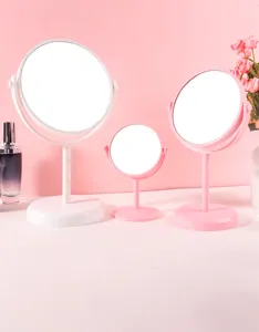 Selectie roze en witte draaibare plastic make-upspiegels voor op de kaptafel in huis