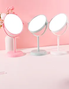 Close-up of rotating desktop makeup mirrors in three pastel colors for vanity decor.