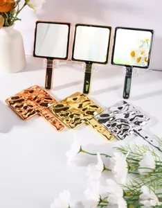 Detail of handheld square mirrors with textured wavy back in gold, silver and rose gold
