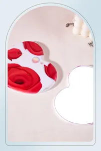 Detailed view of heart-shaped portable makeup mirror with vibrant red rose pattern.