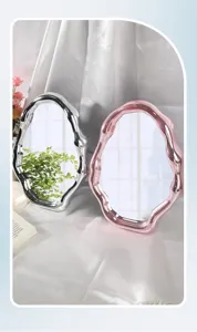 Macro view of two irregular wavy electroplated vanity mirrors in silver and pink