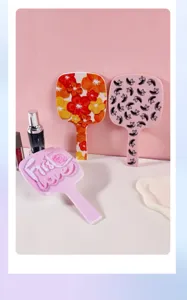 Gedetailleerd overzicht van drie handspiegels met unieke bloemen- en wimperpatronen